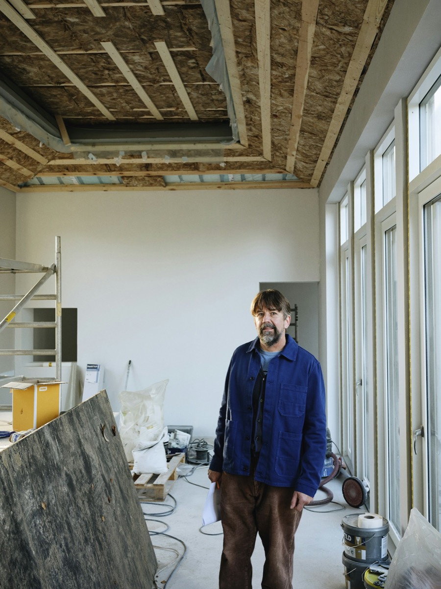 Contractor standing on a renovation site in work clothes, facing the camera
